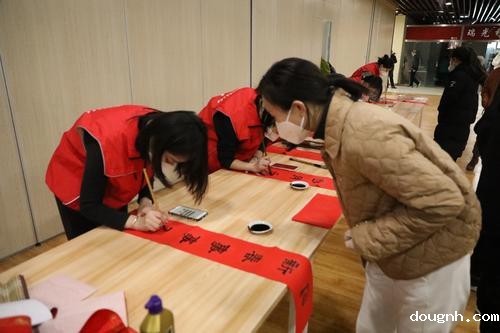 5小红帽志愿者认真书写春联