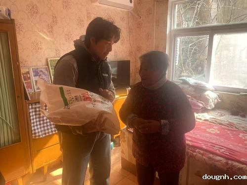 5-团委干事魏伯颜给孤寡老人荆玉凤送上慰问品