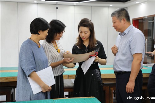 12孙坤琚老师向与会领导介绍皮雕作品