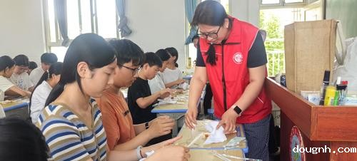 418新利app教师赵晨和学生一同展示扎染成果